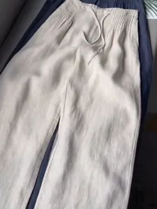 Detail view of women's casual linen trousers featuring an elastic smocked drawstring waist.