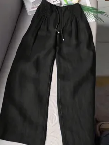 Detail view of black casual wide leg trousers featuring high waist design and comfort drawstring.