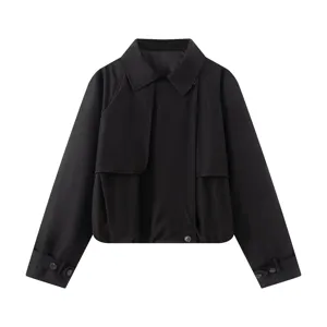 Detailed view of black cropped trench jacket with lapel collar and layered front flap design.