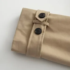 Khaki trench coat sleeve detail close-up, classic cuff strap with dark buttons, neat stitching.