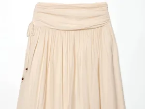 Detailed close-up view of women's beige skirt featuring gathered waist and side drawstring.