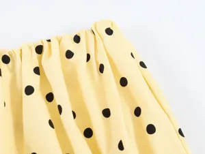 Yellow and black polka dot pleated fabric detail view for women summer clothing style.