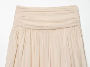 Beige pleated waist detail of women clothing, soft fabric, elegant textured fashion garment.