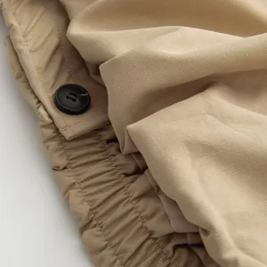 Close-up detail of women's trench coat fabric texture and elastic waist design.