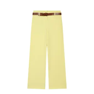 Détail de pantalon large jaune, pantalon casual taille haute avec ceinture marron.