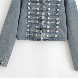 Close up detail of womens blue denim jacket featuring military style braided loop buttons.