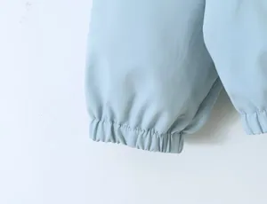 Light blue women's trench coat elastic sleeve cuff detail closeup shot for stylish outerwear.