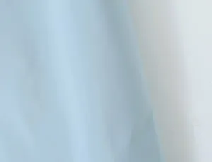 Close-up detail of light blue fabric, showing smooth texture and fine material quality for women.