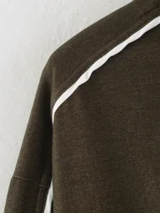 Detail view of women's contrast piping jacket showcasing fine stitching and fabric texture.