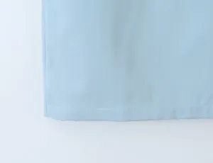 Light blue apparel hem detail, featuring clean white stitching and smooth fabric texture.