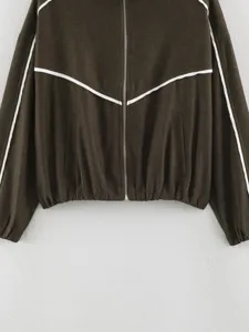 Detailed view of women's contrast piping zip jacket in dark brown with elastic hem.