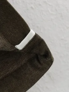 Close-up detail of dark brown selvedge denim fabric, showcasing premium texture and weave.