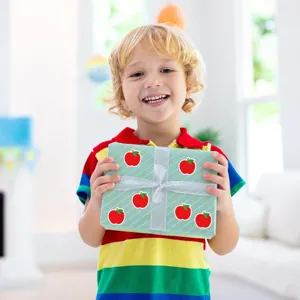 Détail d'autocollants pomme mignons montrant des étiquettes de fruits créatives sur cadeau
