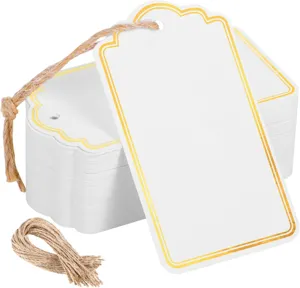 Detailed close-up of blank white paper gift tags with elegant gold foil borders and natural twine.