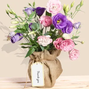 Detailed close-up of a vibrant eustoma flower bouquet wrapped in rustic burlap with a thank you tag.