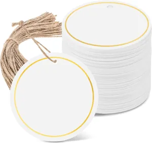 Detailed close-up of round blank white paper gift tags with gold foil borders and twine.