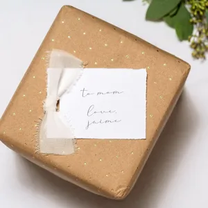 Vista detallada de una caja de regalo de papel kraft con puntos dorados y cinta.