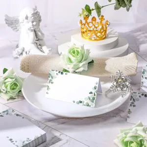 Detailed shot of watercolor eucalyptus wedding place cards on white plate table setting.