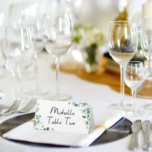 Folded wedding place card with watercolor eucalyptus design for elegant party table settings.