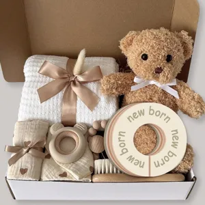 Newborn baby gift set featuring cute teddy bear knitted blanket wooden teether and soft hair brush.