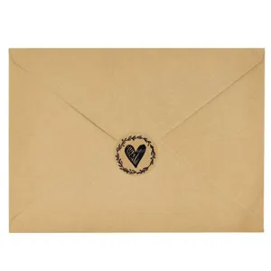 Brown kraft paper envelope with black heart floral wreath seal sticker detail shot