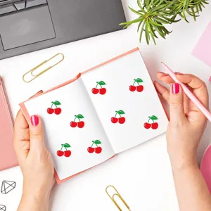 Vue détaillée de jolis autocollants de cerises dans un carnet pour journal et décoration.