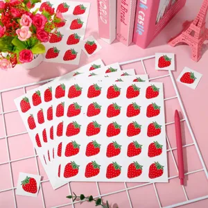 Vue détaillée des adorables feuilles d'autocollants fraise avec un joli décor rose.