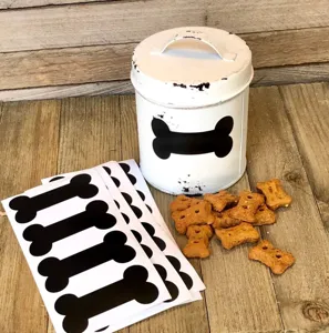 Set di adesivi in PVC a forma di osso di cane nero con barattolo bianco e biscoti.