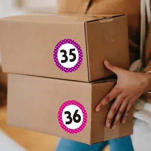 Round number stickers with polka dot pattern applied on shipping boxes for easy identification.