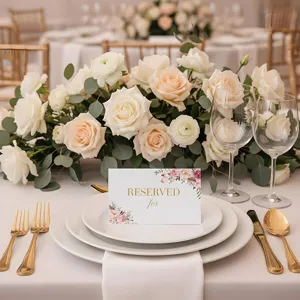 Elegante tarjeta de sitio para boda con diseño floral y letras doradas para decoración de mesa.