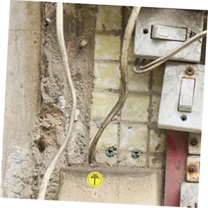 Detalle de pegatina de puesta a tierra industrial, señal amarilla impermeable para equipos eléctricos.