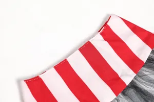 Costume detail view featuring red and white striped fabric with black mesh for Halloween.