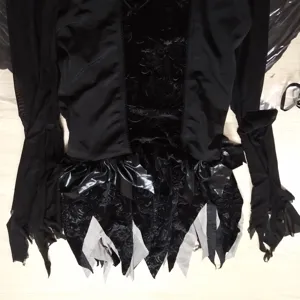 Vue détaillée du costume de cosplay de vampire gothique noir avec manches en tulle et franges.