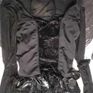 Vue détaillée du haut de cosplay noir gothique avec manches en filet et panneau en velours.