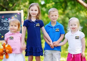 Outdoor scene showing custom name tags worn by children, detailed back to school sticker view.
