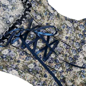 Detailed view of Bavarian dirndl dress featuring blue floral print and satin lacing.