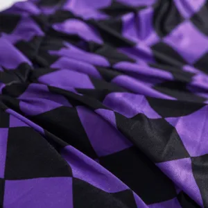 Dettaglio tessuto con motivo a losanghe viola e nero per costume cosplay di Halloween.