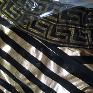 Close-up detail of ancient Greek Roman style costume fabric with metallic gold Greca trim.