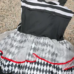 Disfraz de payaso a cuadros en blanco y negro con capas de tul y ribete rojo para fiesta.