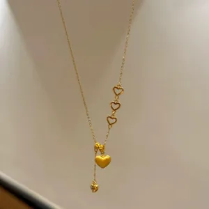 Nahaufnahme der goldenen Herz-Quasten-Halskette mit gebürstetem Anhänger und filigraner Kette.