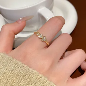 Nahaufnahme des eleganten dreifachen Herzrings mit funkelnden Zirkoniasteinen im Detail.