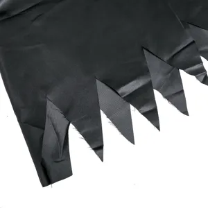 Black jagged hem detail of Halloween costume fabric showing unique cutout design