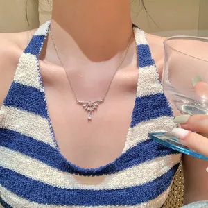 Vista de cerca del detalle de un collar con alas de diamantes brillantes, mostrando mano de obra.