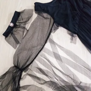 Black mesh gothic costume detail view, showcasing sheer sleeves, layered ruffles and choker.