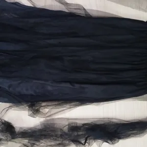 Black mesh fabric detail of Halloween costume, lightweight layered tulle material close up.