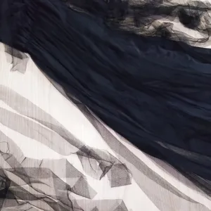 Black tulle fabric detail of Halloween costume, sheer mesh layers for gothic dress design.