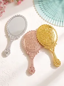 Detail shot of European vintage baroque hand mirrors in silver, gold, and rose gold finishes.