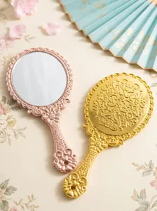 European vintage handheld makeup mirror with baroque relief design and portable handle.