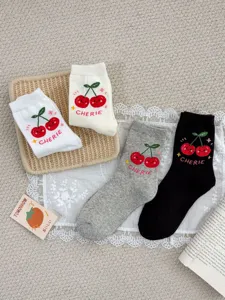 Close-up detail of cute cartoon cherry embroidered combed cotton mid-tube socks in multi-colors.