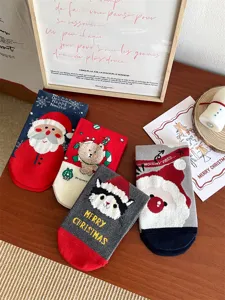 Detailed view of cute Christmas fuzzy socks featuring Santa Claus and animal cartoon designs.
